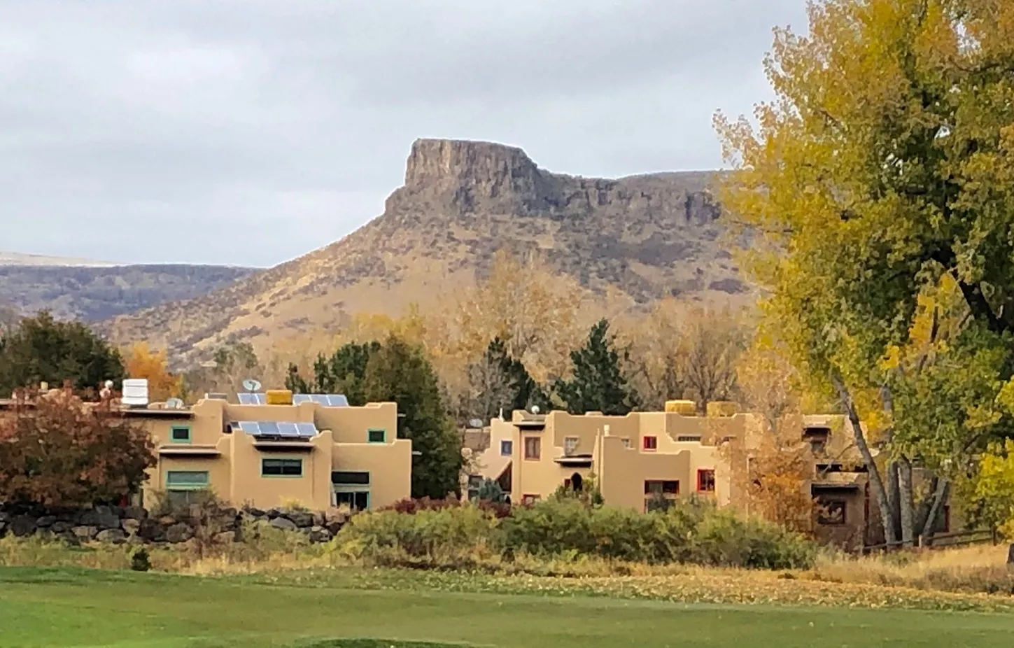 Harmony Village homes with autumn meadow and mesa backdrop