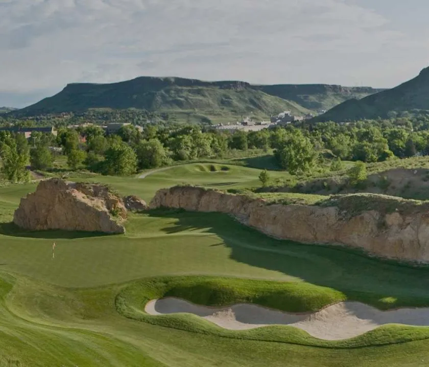 Wide view of Fossil Trace Golf Club with North and South Table Mountains beyond.