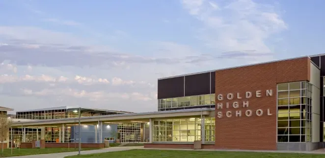Golden High School’s main entrance with students walking under the Demons marquee.