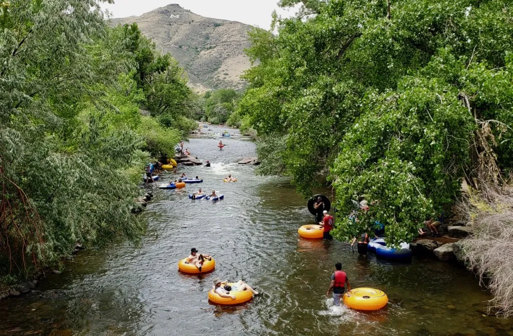 Families and friends floating Clear Creek in bright tubes on a summer afternoon.